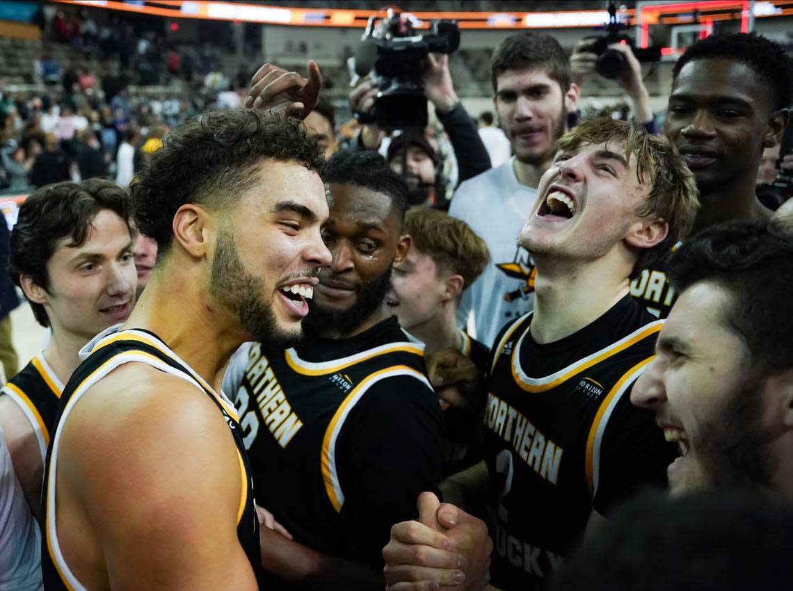 Northern Kentucky guard Trey Robinson, left, and Sam Vinson (2) celebrate with teammates after defeating the Cleveland State Vikings to win the Horizon League Tournament championship in Indianapolis.