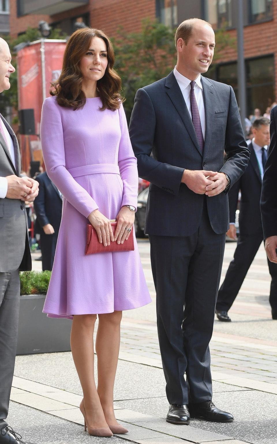 Kate carries an orange clutch bag - Credit: Wireimage