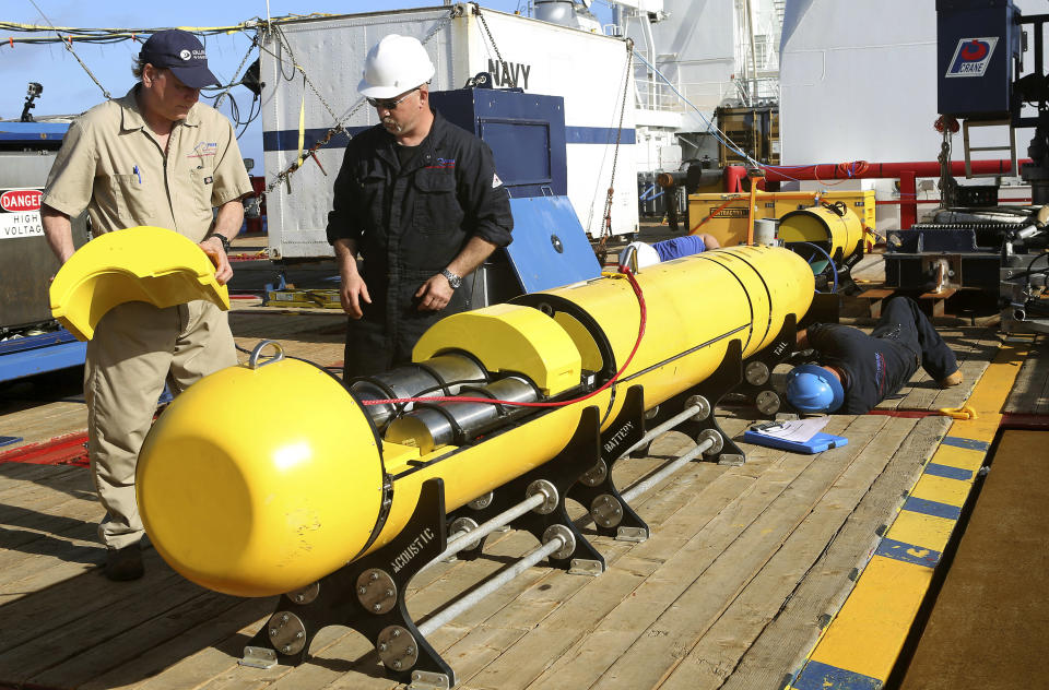 In this Monday, April 14, 2014, photo provided by the Australian Defense Force Phoenix International's Chris Minor, right, and Curt Newport inspect an autonomous underwater vehicle before it is deployed from ADV Ocean Shield in the search of the missing Malaysia Airlines Flight 370 in the southern Indian Ocean. The search area for the missing Malaysian jet has proved too deep for the robotic submarine which was hauled back to the surface of the Indian Ocean less than half way through its first seabed hunt for wreckage and the all-important black boxes, authorities said on Tuesday. (AP Photo/Australian Defense Force, Lt. Kelli Lunt) EDITORIAL USE ONLY