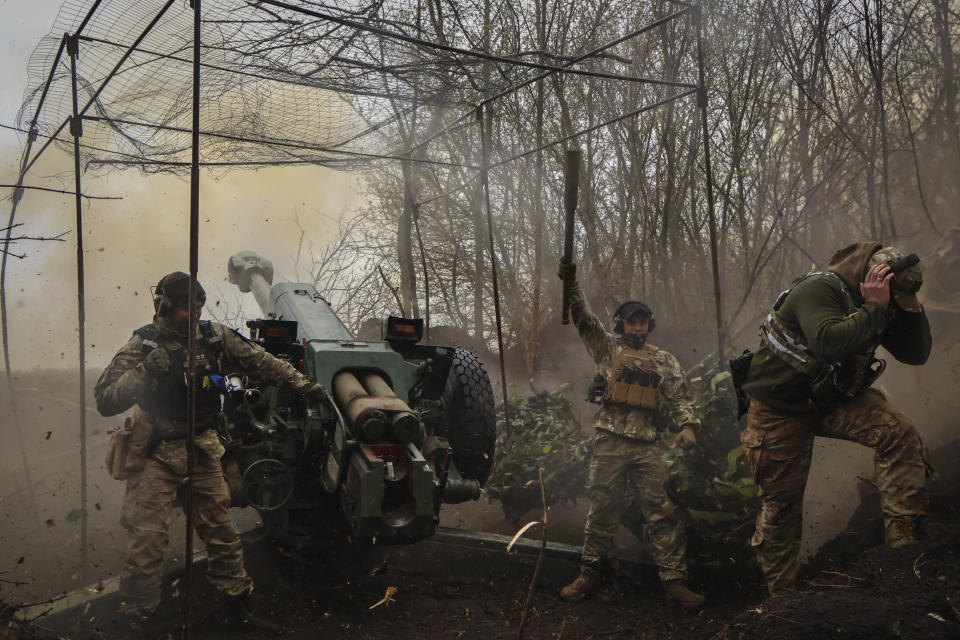 FILE - Ukrainian soldiers fire a howitzer D-30 at the frontline near Bakhmut, Donetsk region, Ukraine, Wednesday, April 19, 2023. Ukrainian President Volodymyr Zelenskyy said Sunday, May 21, 2023 that Russian forces weren't occupying Bakhmut, casting doubt on Moscow's insistence that the eastern Ukrainian city had fallen. The fog of war made it impossible to confirm the situation on the ground in the invasion’s longest battle, and the comments from Ukrainian and Russian officials added confusion to the matter. (Roman Chop via AP, File)