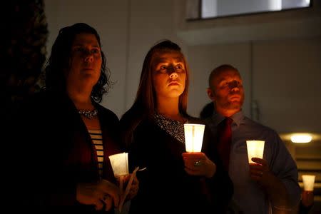 People hold candles during a vigil for San Bernardino County employees after last week's shooting in San Bernardino, California December 7, 2015. REUTERS/Patrick T. Fallon