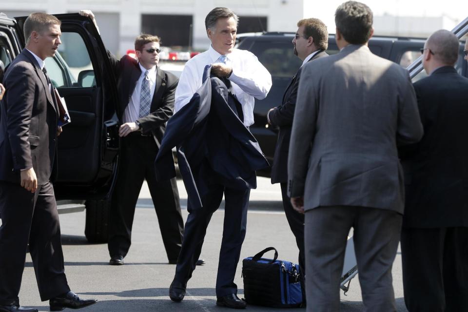 Republican presidential candidate, former Massachusetts Gov. Mitt Romney puts on his jacket before boarding his campaign charter plane in Newark, N.J., Friday, Sept. 14, 2012. (AP Photo/Charles Dharapak)