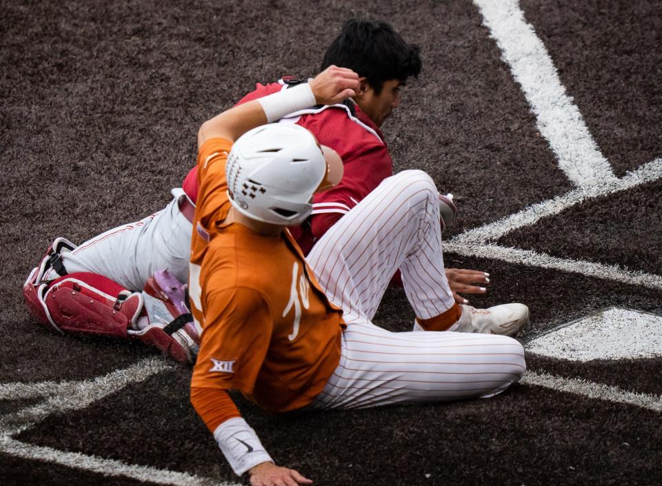 Texas' Peyton Powell slides home safely just ahead of a tag by Oklahoma catcher Diego Muniz in the fifth inning of Saturday's first game. There were few bright moments for the Longhorns as they were swept by the Sooners and fell from first to fourth place in the Big 12 standings.