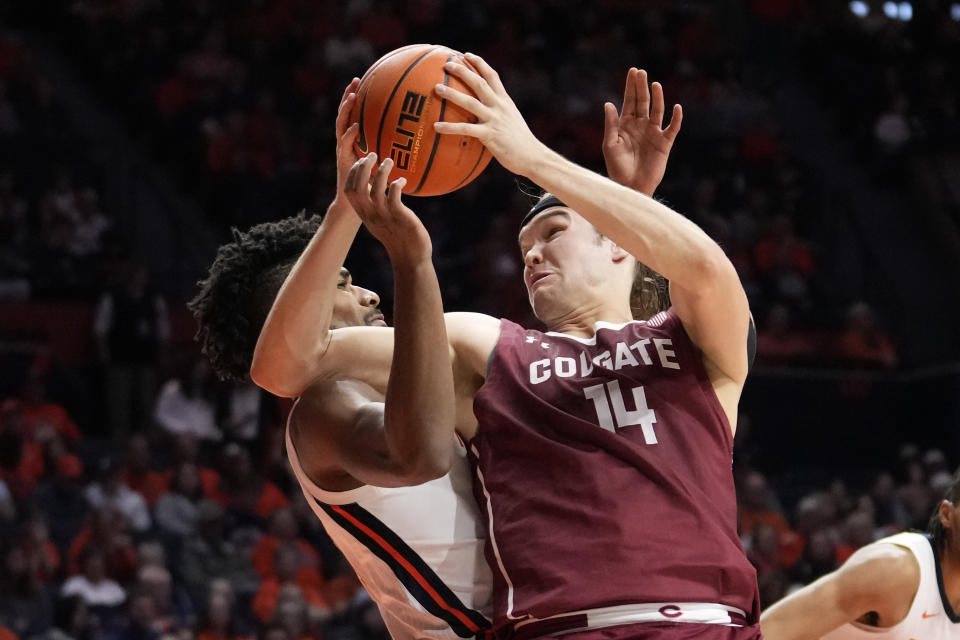Colgate's Keegan Records muscles his way to the basket as Illinois' Quincy Guerrier defends during the second half of an NCAA college basketball game Sunday, Dec. 17, 2023, in Champaign, Ill. Illinois won 74-57. (AP Photo/Charles Rex Arbogast)