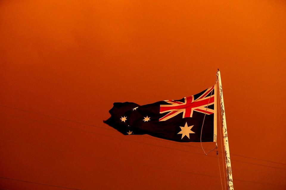 The Australia Flag flies under red skies from the fires on Jan. 4. 