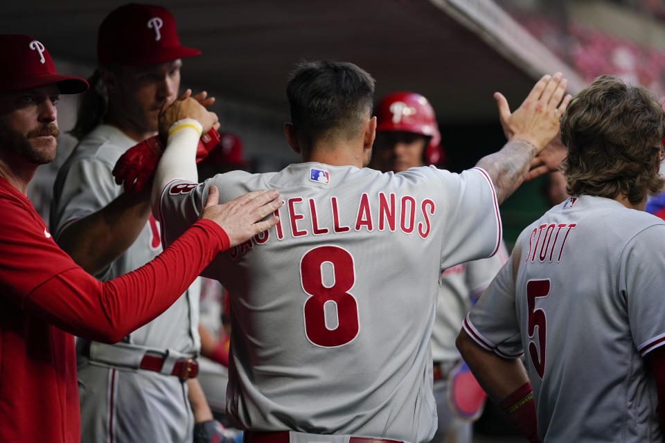 Philadelphia Phillies' Nick Castellanos (8) celebrates with teammates after scoring on an Edmundo Sosa single during the third inning of the team's baseball game against the Cincinnati Reds on Monday, Aug. 15, 2022, in Cincinnati. (AP Photo/Jeff Dean)