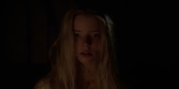 A close-up of Thomasin in the dark in "The Witch"