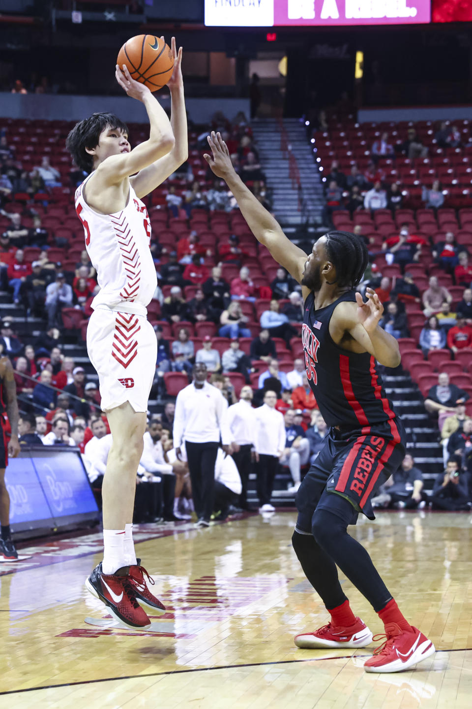 Dayton forward Mike Sharavjamts, left, shoots over UNLV guard EJ Harkless during the first half of an NCAA college basketball game Tuesday, Nov. 15, 2022, in Las Vegas. (AP Photo/Chase Stevens)