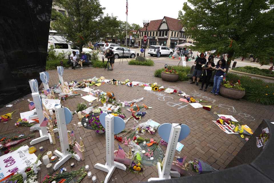 People visit a memorial for those injured and killed in Monday's Fourth of July mass shooting, Wednesday, July 6, 2022, in Highland Park, Ill. (AP Photo/Charles Rex Arbogast)