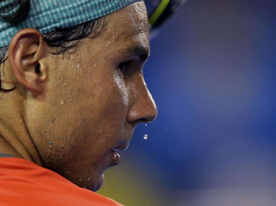 Sweat drips from the face of Rafael Nadal of Spain during a break in his first round match against Bernard Tomic of Australia at the Australian Open tennis championship in Melbourne, Australia, Tuesday, Jan. 14, 2014.(AP Photo/Rick Rycroft)