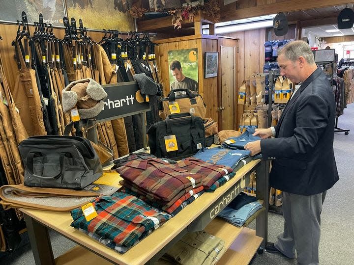 Jim Pope, of Powers Clothing in Jonesville, tends to inventory Tuesday as the store prepares for holiday shoppers.