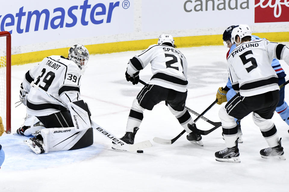 Los Angeles Kings goaltender Cam Talbot (39) makes a save on Winnipeg Jets' Cole Perfetti, back right, as Jordan Spence (21) and Andreas Englund (5) defend during the first period of an NHL hockey game in Winnipeg, Manitoba, on Monday, April 1, 2024. (Fred Greenslade/The Canadian Press via AP)