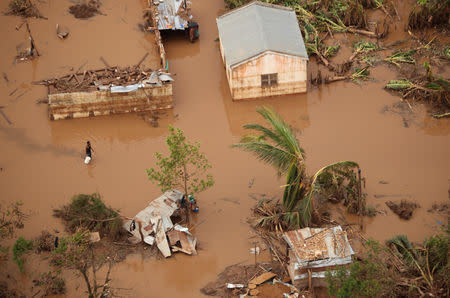 People walk through floodwater near Beira, Mozambique, in the aftermath of Cyclone Idai, March 23, 2019. REUTERS/Mike Hutchings