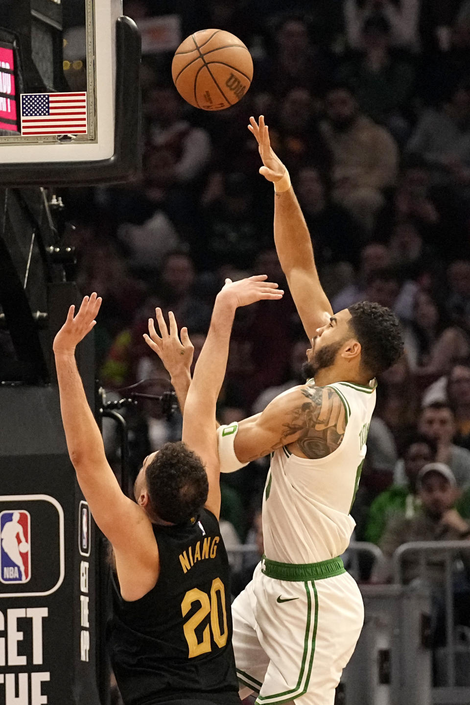 Boston Celtics forward Jayson Tatum, right, shoots in front of Cleveland Cavaliers forward Georges Niang (20) in the first half of an NBA basketball game, Tuesday, March 5, 2024, in Cleveland. (AP Photo/Sue Ogrocki)