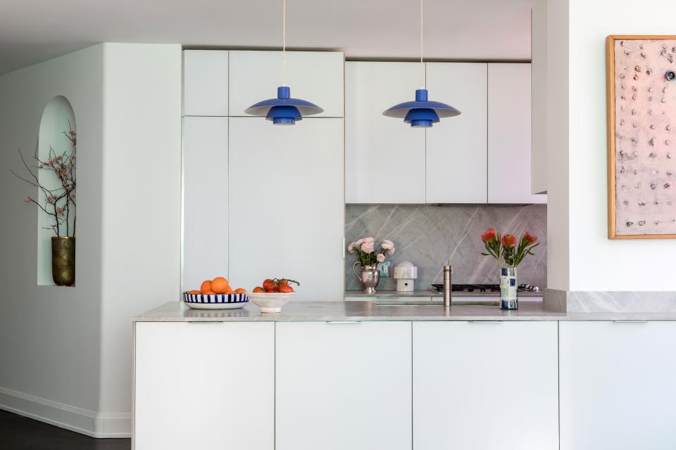 In a Chelsea renovation, the owner’s artwork—both large-scale canvases and ceramics—“made it really easy to style,” says interior designer Patrick McGrath, who had lots at his disposal when accessorizing the apartment. On the clean and minimal kitchen island sit two blue and white pieces she made.