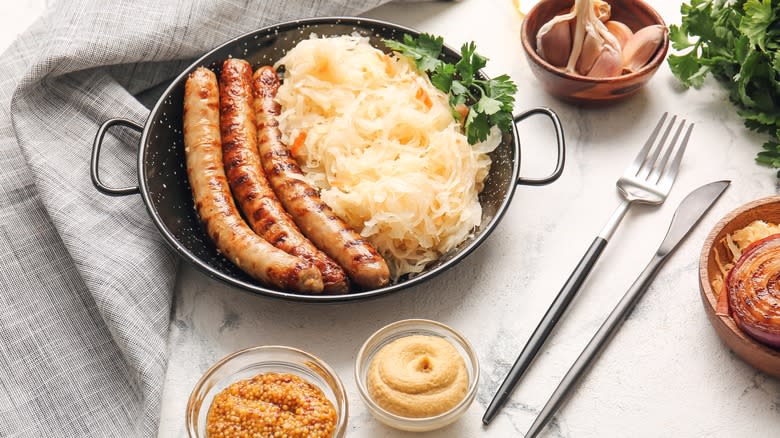 sauerkraut with sausages and mustard on table