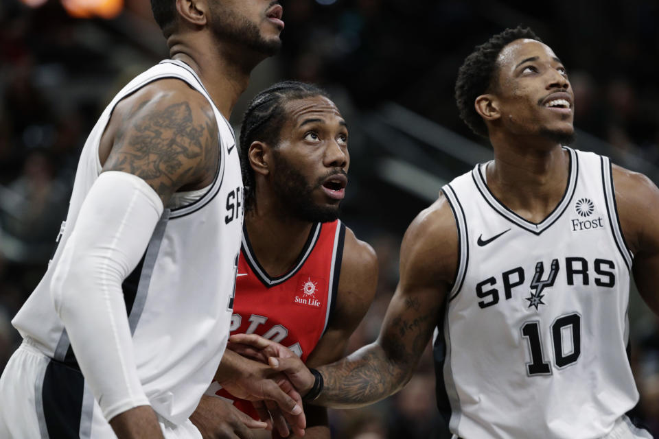 Toronto Raptors forward Kawhi Leonard (2) and San Antonio Spurs guard DeMar DeRozan (10) jockey for a rebound during the first half of an NBA basketball game, Thursday, Jan. 3, 2019, in San Antonio. (AP Photo/Eric Gay)