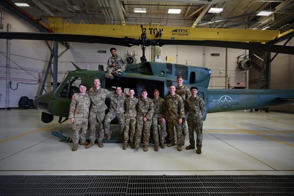 Airmen assigned to the 40th Helicopter Squadron stand for a group photo in front of a UH-1N Huey helicopter following an arrival ceremony for the MH-139A Grey Wolf on March 9 at Malmstrom Air Force Base.