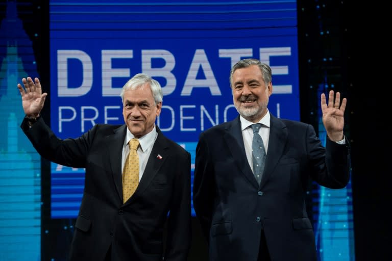 Chilean presidential candidates Sebastian Pinera (L) and Alejandro Guillier wave to supporters ahead of a televised debate in Santiago