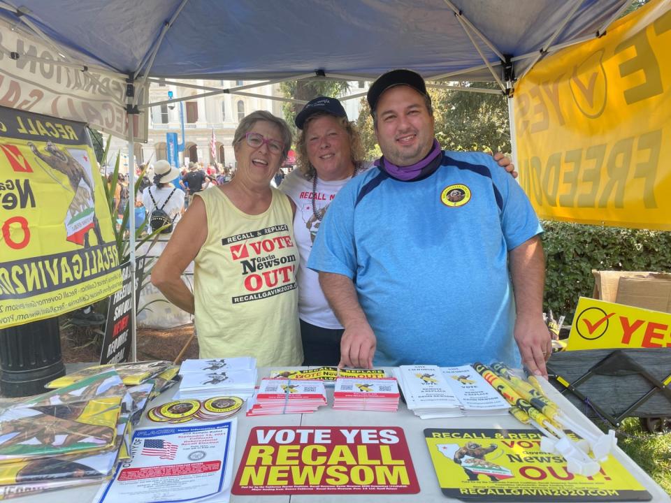 Stephanie Suela, Linda Rich and Matt Francis man a booth in support of recalling Gov. Gavin Newsom.