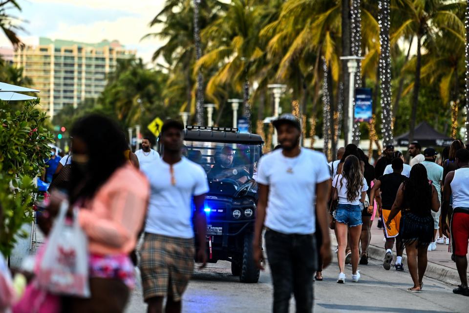 Police in a buggy patrol a crowded street in Miami Beach, Florida.