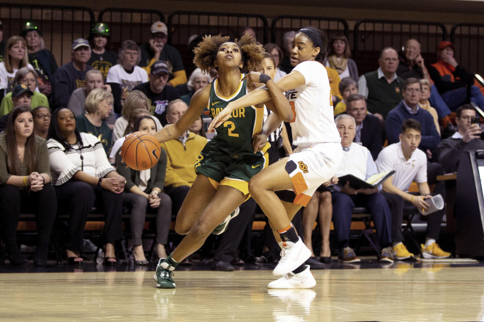 Baylor guard DiDi Richards (2) drives the basketball while under defensive pressure from Oklahoma State guard Lauren Fields (23) during the second half of an NCAA college basketball game in Stillwater, Okla., Saturday, Feb. 15, 2020. (AP Photo/Brody Schmidt)