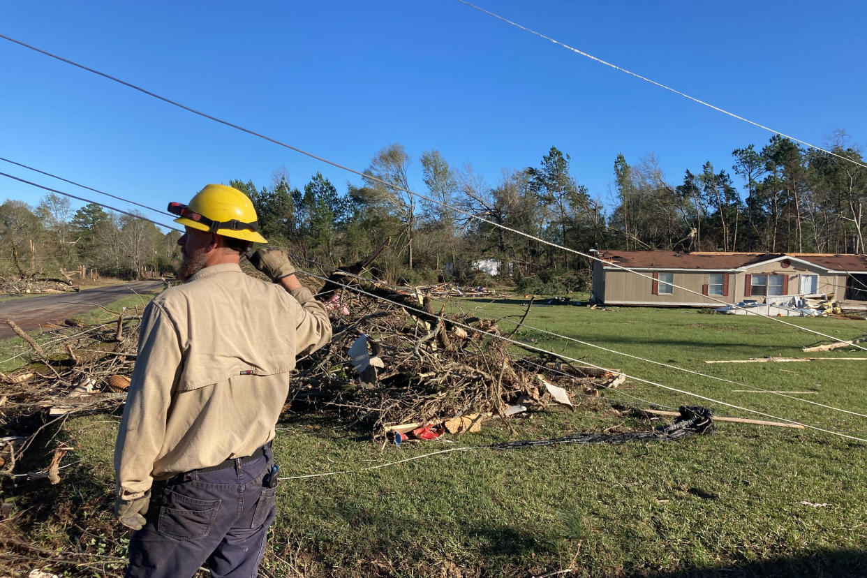 A utility worker checks lines following severe weather Wednesday, Dec. 14, 2022, in Keithville, La. A volatile storm ripping across the U.S. spawned tornadoes that killed a young boy and his mother in Louisiana, smashed mobile homes and chicken houses in Mississippi and threatened neighboring Southern states with more punishing weather Wednesday. (AP Photo/Jake Bleiberg)