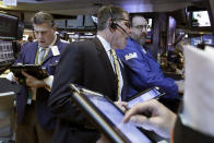 Trader Sean Spain, center, works on the floor of the New York Stock Exchange, Wednesday, March 29, 2017. Stocks are opening mostly lower on Wall Street led by declines in utilities and real estate companies. (AP Photo/Richard Drew)