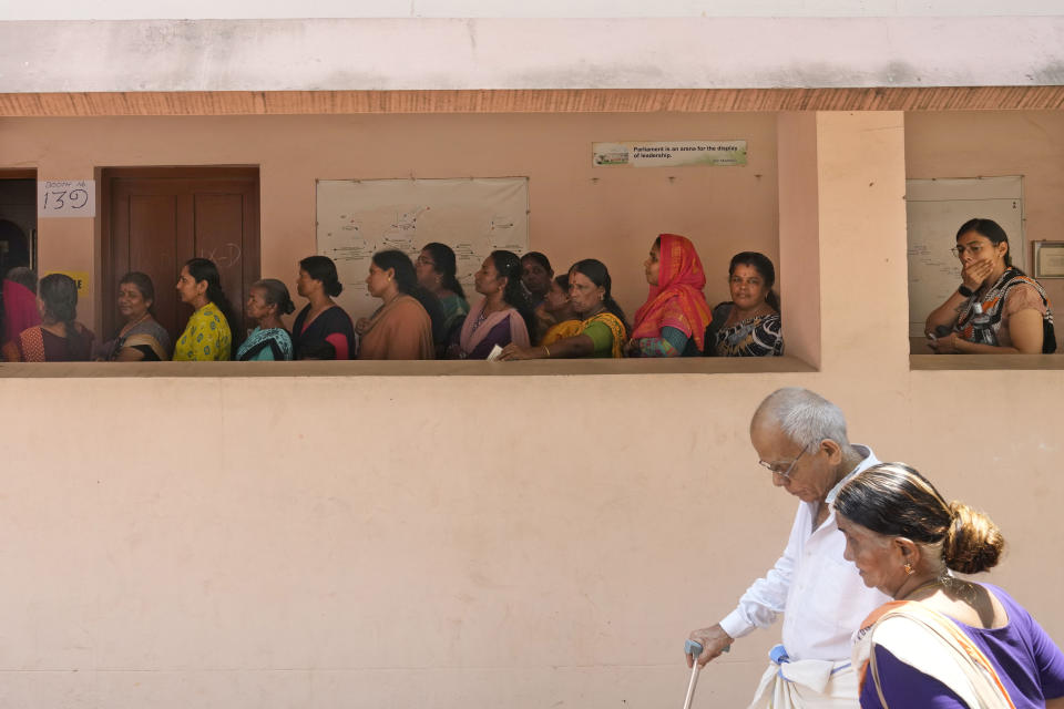 An elderly couple arrive as others wait in a queue to cast their vote during the second phase of national election in Palakkad, Kerala, India, Friday, April 26, 2024. (AP Photo/Manish Swarup)
