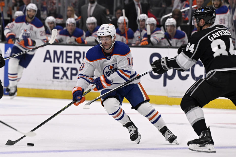 Edmonton Oilers center Derek Ryan (10) controls the puck with pressure from Los Angeles Kings defenseman Vladislav Gavrikov (84) during the first period of an NHL hockey game in Los Angeles, Saturday, Feb. 10, 2024. (AP Photo/Alex Gallardo)