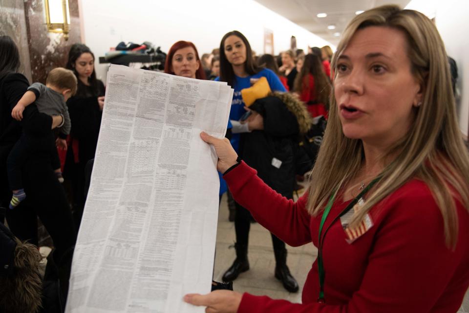 An Anti-Vaccination parent holds up a prescription document as she waits with others to get into a hearing where Ethan Lindenberger, a student at Norwalk High School in Norwalk, Ohio, who confided in a now-viral Reddit post that he had not been fully vaccinated due to his mother's belief that vaccines are dangerous, speaks before the Senate Committee on Health, Education, Labor and Pensions on Capitol Hill in Washington, DC, on March 5, 2019. (Photo by Jim WATSON / AFP)        (Photo credit should read JIM WATSON/AFP via Getty Images)