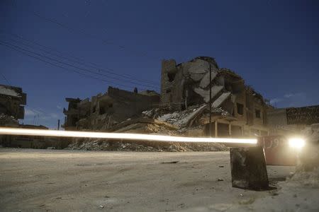 Damaged buildings are pictured at night in the rebel-controlled area of Maaret al-Numan town in Idlib province, Syria December 26, 2015. Picture taken with long exposure. REUTERS/Khalil Ashawi