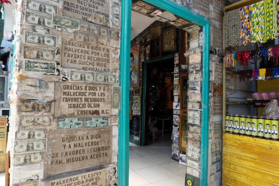 Dólares y lápidas colocadas en las paredes de la Capilla de Jesús Malverde (Independent en Español / José Luis Montenegro)