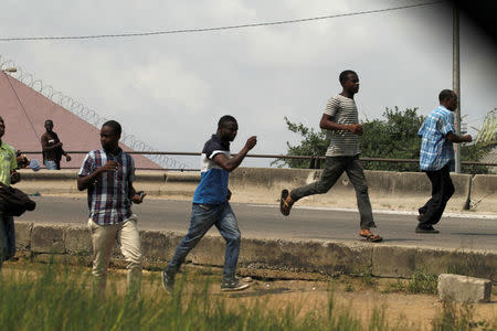 People run as they leave the port of Abidjan after hearing gunfire in Abidjan, Ivory Coast January 18, 2017. REUTERS/Luc Gnago