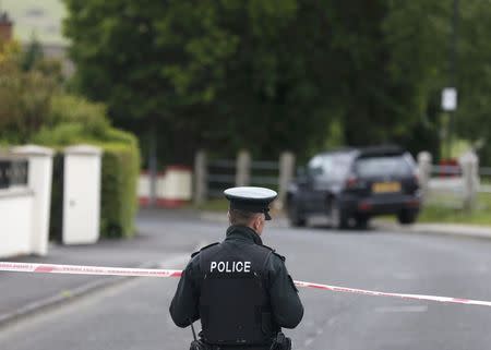 A police officer stands on duty on a street closed off after an explosive device was found under a serving police officer's car in Londonderry, Northern Ireland, June 18, 2015. REUTERS/Cathal McNaughton