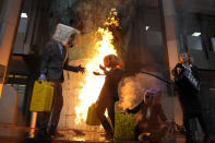 Ocean Rebellion demonstrators protest outside the International Maritime Organisation against the use of fossil fuels in the shipping industry, in London, Monday, Nov. 21, 2022. (AP Photo/Alastair Grant)