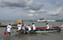 In this photo provided by Bidyanondo Foundation, volunteers load medical supplies to be carried on boat hospital, in Chandpur District in eastern Bangladesh, on Sept. 12, 2020. A Bangladeshi charity has set up a floating hospital turning a small tourist boat into a healthcare facility to provide services to thousands of people affected by this year's devastating floods that marooned millions. (Bidyanondo Foundation via AP)