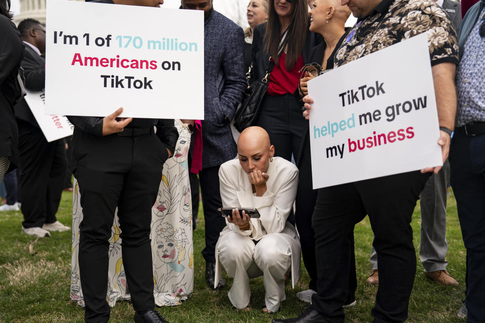 Emmy Combs, creadora de TikTok y maquillista que sufre alopecia, al centro, cerca de otros partidarios de TikTok reunidos frente al Capitolio, observa una transmisión de la votación en la Cámara de Representantes, el 13 de marzo de 2024. (Kent Nishimura/The New York Times).