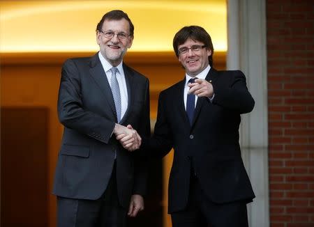 Spanish acting Prime Minister Mariano Rajoy (L) and Catalan President Carles Puigdemont gesture while posing for the media at the Moncloa Palace in Madrid, Spain, April 20, 2016. REUTERS/Susana Vera