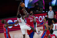 Washington Wizards center Thomas Bryant (13) and Philadelphia 76ers center Joel Embiid (21) go for a rebound during the second half of an NBA basketball game Wednesday, Aug. 5, 2020 in Lake Buena Vista, Fla. (AP Photo/Ashley Landis)