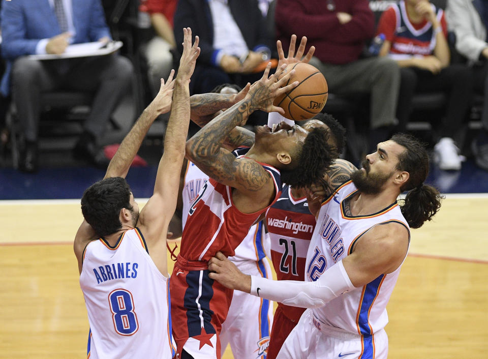 Oklahoma City Thunder center Steven Adams (12), of New Zealand, and guard Alex Abrines (8), of Spain, defend against Washington Wizards forward Kelly Oubre Jr., center, during the first half of an NBA basketball game Friday, Nov. 2, 2018, in Washington. (AP Photo/Nick Wass)