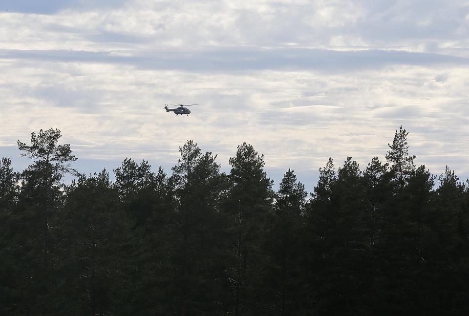 A helicopter flies over the area near the Jamijarvi Airfield, southwest Finland, where a small passenger plane carrying parachuters fell to the ground, Sunday April 20, 2014. At least three people were killed in the crash, three were rescued and five are still missing, local media have reported. (AP Photo/Mika Kenerva, Lehtikuva) FINLAND OUT
