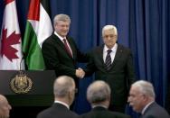 Canada's Prime Minister Stephen Harper (L) and Palestinian President Mahmoud Abbas shake hands after their joint news conference in the West Bank city of Ramallah January 20, 2014. Harper is on a four-day visit to Israel and the Palestinian Territories. REUTERS/Darren Whiteside (WEST BANK - Tags: POLITICS)