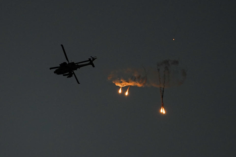 Un helicóptero Apache israelí lanza bengalas sobre la Franja de Gaza, visto desde el sur de Israel, el 1 de noviembre de 2023. (AP Foto/Ariel Schalit)
