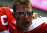 A fan with a Canadian flag painted on his face reacts before the men's ice hockey gold medal game between Sweden and Canada at the Sochi 2014 Winter Olympic Games February 23, 2014. REUTERS/Mark Blinch (RUSSIA - Tags: OLYMPICS SPORT ICE HOCKEY)