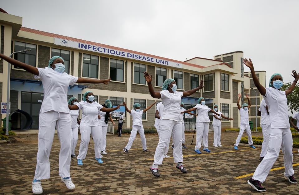 Nurses who take care of coronavirus patients at the infectious disease unit take part in a Zumba dance-fitness class put on to help them deal with the stress and difficult work, in the car park outside of the Kenyatta University Teaching, Referral and Research Hospital in Nairobi, Kenya Sunday, May 17, 2020. (AP Photo/Brian Inganga)