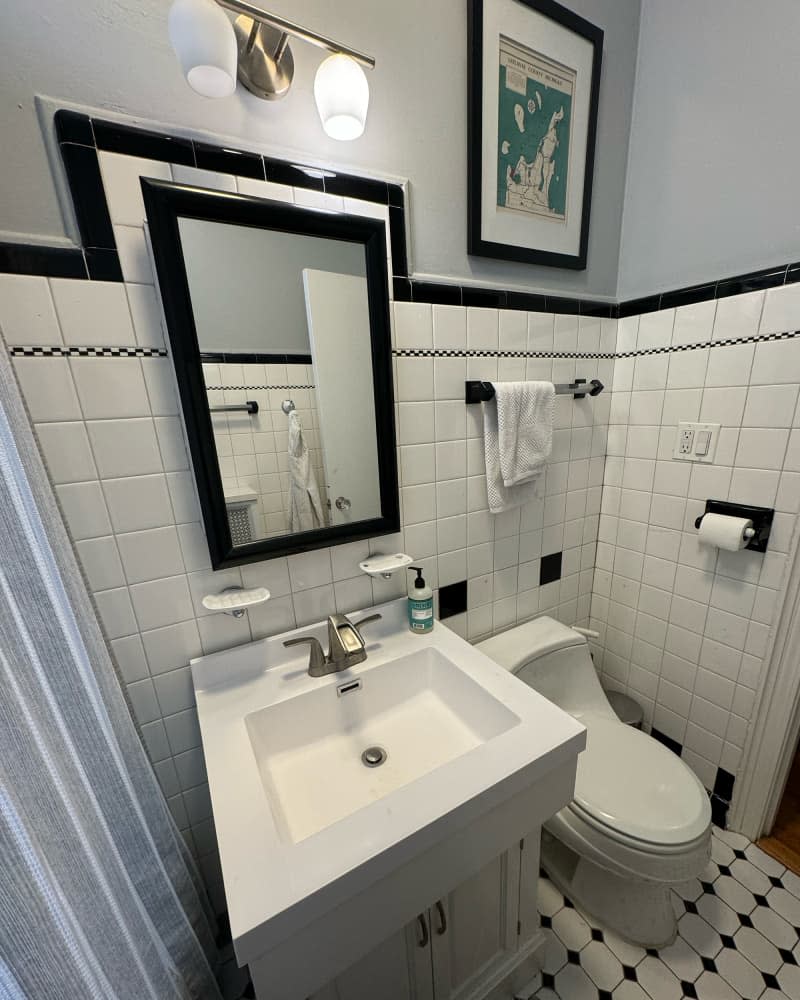 Black and white tiles in bathroom before renovation.