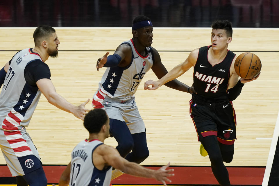 Miami Heat guard Tyler Herro (14) looks to pass the ball surrounded by Washington Wizards center Alex Len (27), guard Jerome Robinson (12) and forward Isaac Bonga (17), during the second half of an NBA basketball game, Friday, Feb. 5, 2021, in Miami. (AP Photo/Marta Lavandier)