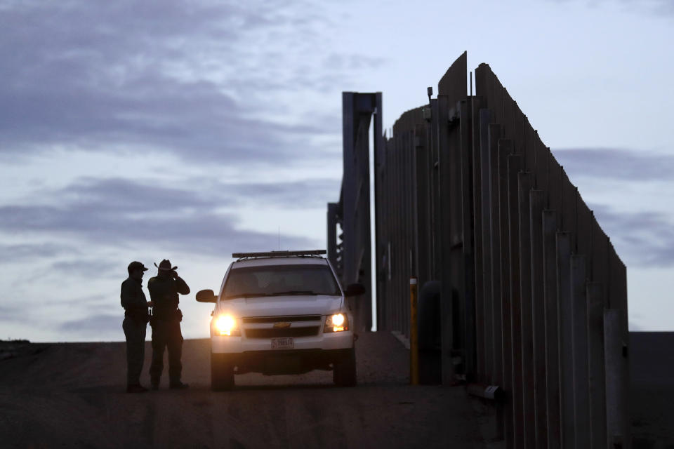 FILE - In this Wednesday, Nov. 21, 2018 file photo, United States Border Patrol agents stand by a vehicle near one of the border walls separating Tijuana, Mexico and San Diego, in San Diego. President Donald Trump's administration on Tuesday, Nov. 27, 2018, said it would appeal a judge's order barring it from enforcing a ban on asylum for any immigrants who illegally cross the U.S.-Mexico border, after the president's attack on the judge prompted an extraordinary rebuke from the nation's chief justice. (AP Photo/Gregory Bull, File)