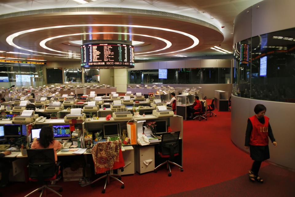 A trader walks inside the trading hall during afternoon trading at the Hong Kong Stock Exchange April 10, 2014. China's securities regulator and its Hong Kong counterpart said on Thursday they would allow mainland investors to trade shares in designated companies listed in Hong Kong, while letting Hong Kong investors buy selected Shanghai-listed shares. REUTERS/Bobby Yip (CHINA - Tags: BUSINESS POLITICS)